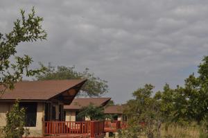 een huis met een terras en bomen ervoor bij Elephant Rock Luxury Camp Tarangire in Kaiti