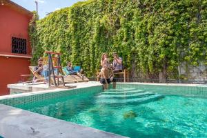 un groupe de personnes assises autour d'une piscine dans l'établissement Socialtel Antigua - formerly Selina Antigua, à Antigua Guatemala