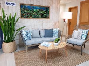 ein Wohnzimmer mit einem Sofa, 2 Stühlen und einem Tisch in der Unterkunft Apartamentos Guadiana in Monte Gordo