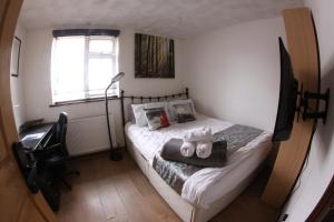 una piccola camera con letto e sedia di College Street Abode a Portsmouth