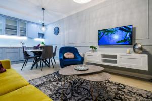 Uma televisão e/ou sistema de entretenimento em DiVine Luxury Apartment Purple