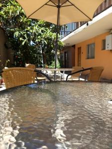 een zwembad met een parasol en stoelen en een tafel bij Piezas con Baño Privado Economicas in La Serena