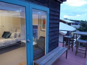 une porte coulissante en verre sur un balcon avec un banc dans l'établissement Port Central No 2, à Port Campbell