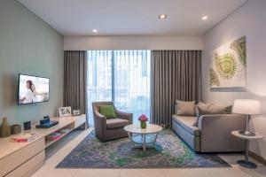 a living room with a couch and a chair at Citadines OMR Chennai in Chennai