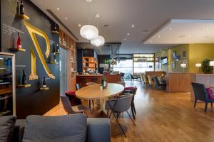 a restaurant with a table and chairs and a dining room at Mercure Hotel Mannheim am Rathaus in Mannheim