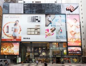 un edificio con grandes anuncios a su lado en Holiday Inn Express Hong Kong Causeway Bay, an IHG Hotel, en Hong Kong