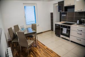 y cocina con mesa, sillas y fogones. en Apartamenty KORONA, en Krosno