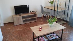 - un salon avec une télévision et une table dans l'établissement Central Location, à Nauplie