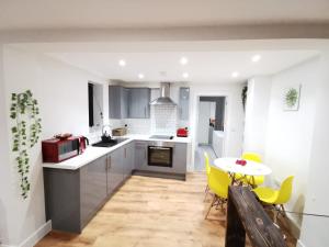 uma cozinha com uma mesa e cadeiras amarelas em 4 sleeps and travel cot- close to beach and restaurants em Bournemouth