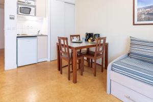 - une petite cuisine avec une table et des chaises dans la chambre dans l'établissement Residhotel Grenette, à Grenoble