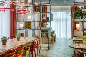 a restaurant with a long table and chairs at IntercityHotel Hannover Hauptbahnhof-Ost in Hannover