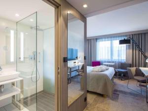 a hotel room with a bed and a bathroom at Mercure Krakow Stare Miasto in Kraków