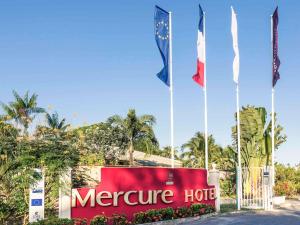 un cartello per un hotel mercure con tre bandiere di Mercure Cayenne Royal Amazonia a Cayenne