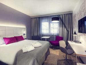 a bedroom with a large bed and a table and chairs at Mercure Krakow Stare Miasto in Kraków