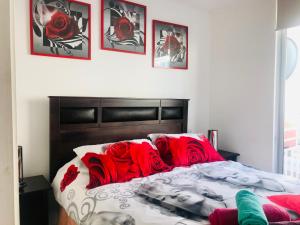 Un dormitorio con una cama con almohadas rojas. en Cosmopolita Rojo, en La Serena