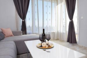 a living room with a couch and a table with wine glasses at Niko's Sea View Apartments Deluxe in Nesebar