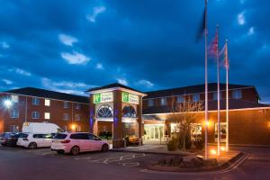 a building with cars parked in a parking lot at Holiday Inn Express Southampton West, an IHG Hotel in Southampton