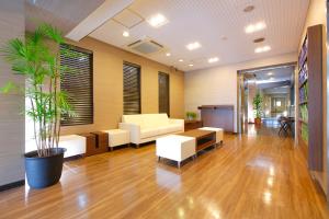 an office lobby with white furniture and a potted plant at FLEXSTAY INN Ekoda in Tokyo