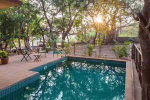 una piscina in un cortile con un albero di Antilia Villa - Luxurious-AC-Swimming pool a Panchgani