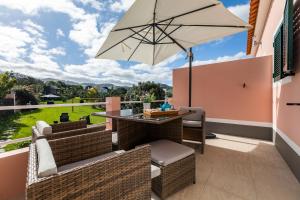 un patio con mesa y sombrilla en Atlantico Apartments, en Ribeira Grande