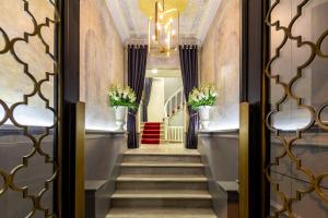 a hallway with stairs with a chandelier and flowers at The Soul Istanbul Hotel in Istanbul