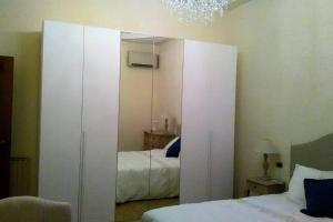 1 dormitorio con armario blanco grande y cama en Charming Family Lodge With Private Garage, en Florencia