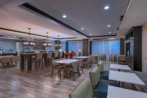 een restaurant met tafels en stoelen en een bar bij Holiday Inn Express & Suites Austin NW - Four Points, an IHG Hotel in Four Points