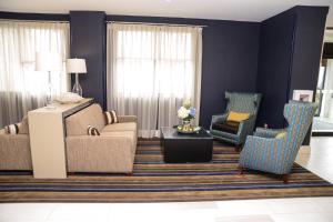 uma sala de estar com um sofá e duas cadeiras em Holiday Inn Express Baltimore West - Catonsville, an IHG Hotel em Catonsville