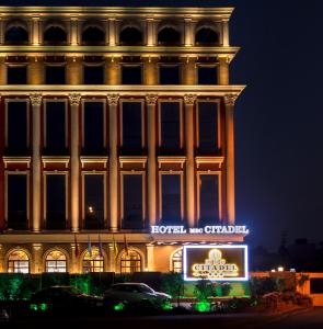 a building with a sign in front of it at night at Hotel MBC Citadel Nashik in Nashik