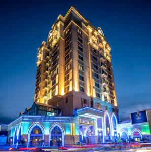 Un grand bâtiment avec des lumières allumées la nuit dans l'établissement Merit Lefkosa Hotel & Casino, à Lefkosa Turk