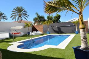 einen Pool im Garten mit Palmen in der Unterkunft Villa Olivia Maspalomas with private pool in Maspalomas