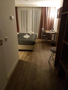 Pokój hotelowy z łóżkiem, biurkiem i stołem w obiekcie Hotel Hague Center w Hadze