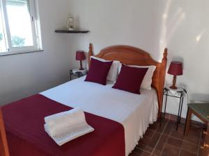 1 dormitorio con 1 cama grande con sábanas rojas y blancas en Quinta Das Lameirinhas, en Marvão