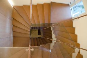 a spiral staircase in a room with a glass floor at Stay COOPER l Goethe Guesthouse in Bolzano