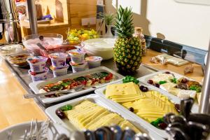 um balcão com várias bandejas de comida e um ananás em Nordsee-Hotel Hinrichsen em Husum