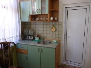 a small kitchen with a sink and a door at Guest House Zhelevi in Sozopol