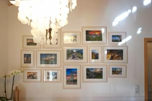 un mur de photos sur un mur avec un lustre dans l'établissement Harzer Feriengarten, à Quedlinbourg