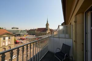 d'un balcon avec une chaise et une vue sur la ville. dans l'établissement Hotel City am Bahnhof, à Berne