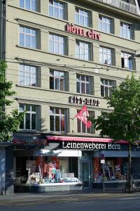 un grand bâtiment avec un panneau d'hôtel dans l'établissement Hotel City am Bahnhof, à Berne