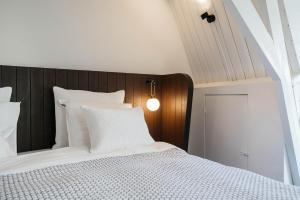 a bedroom with a white bed with a wooden headboard at Cozy Pillow in Utrecht