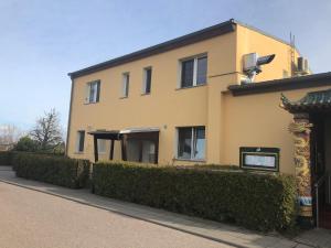 a yellow building with bushes in front of it at Asiatisches Landhaus in Braunsbedra