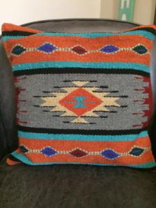 a pillow on a chair with a blanket on it at Sitzmark Chalet Inn in Ruidoso