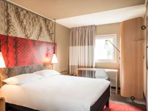 een hotelkamer met een groot wit bed en een raam bij ibis Edinburgh Centre Royal Mile – Hunter Square in Edinburgh