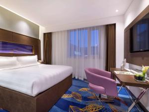 Ένα ή περισσότερα κρεβάτια σε δωμάτιο στο Novotel Beijing Peace