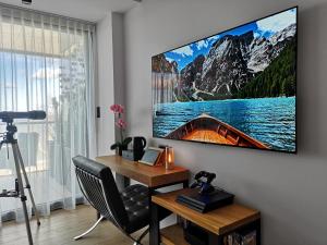 Pokój z telewizorem wiszącym na ścianie i biurkiem w obiekcie Sea View Moss VIP Apartment w Kołobrzegu