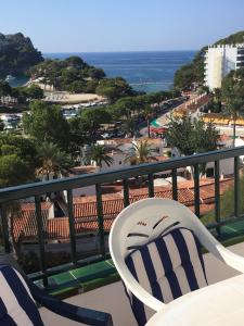 uma varanda com uma cadeira e vista para o oceano em Apartamentos Encanto Del Mar em Cala Galdana