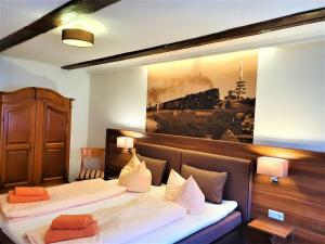 two beds in a room with a painting on the wall at Apart Hotel Wernigerode in Wernigerode