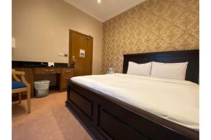 Dormitorio con cama grande, escritorio y cama sidx sidx en SK Baylis House Hotel, en Slough