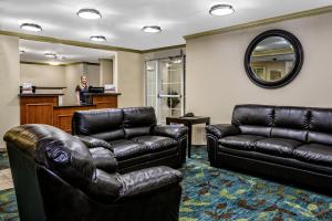 een wachtkamer met lederen meubels en een spiegel bij Candlewood Suites Galveston, an IHG Hotel in Galveston