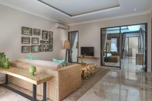 a living room with a couch and a tv at Nunamkhalu Private Villa and Spa in Nusa Dua